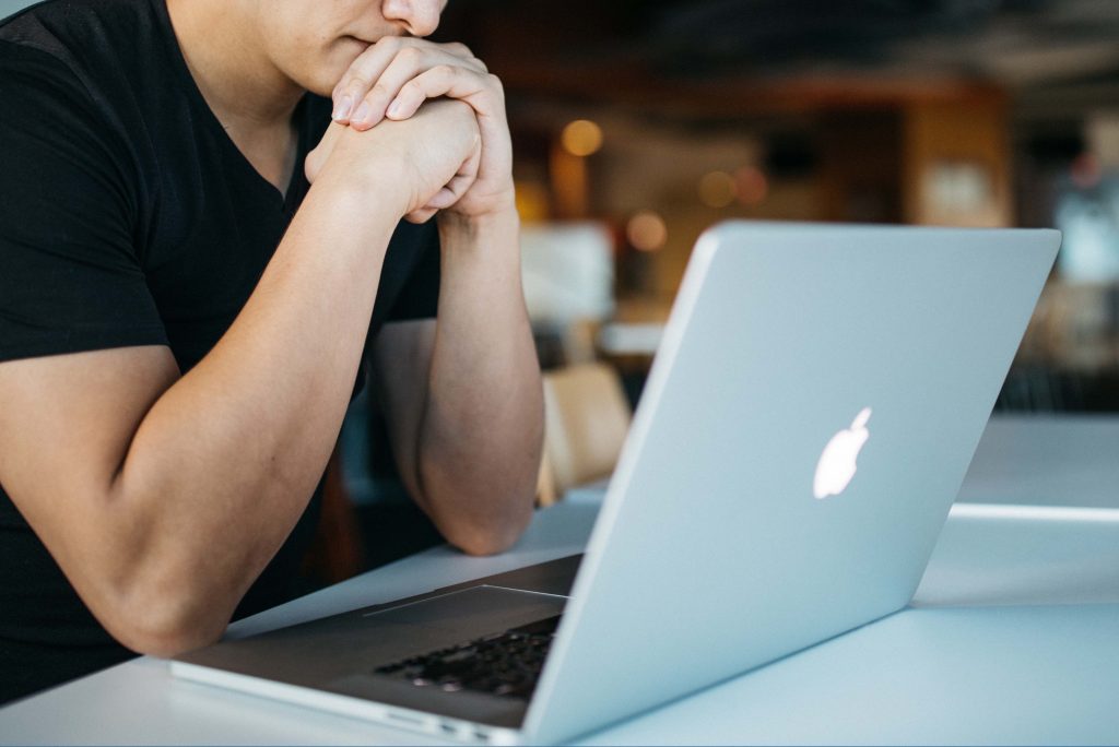 Profissionais trabalhando com MacBooks em uma mesa